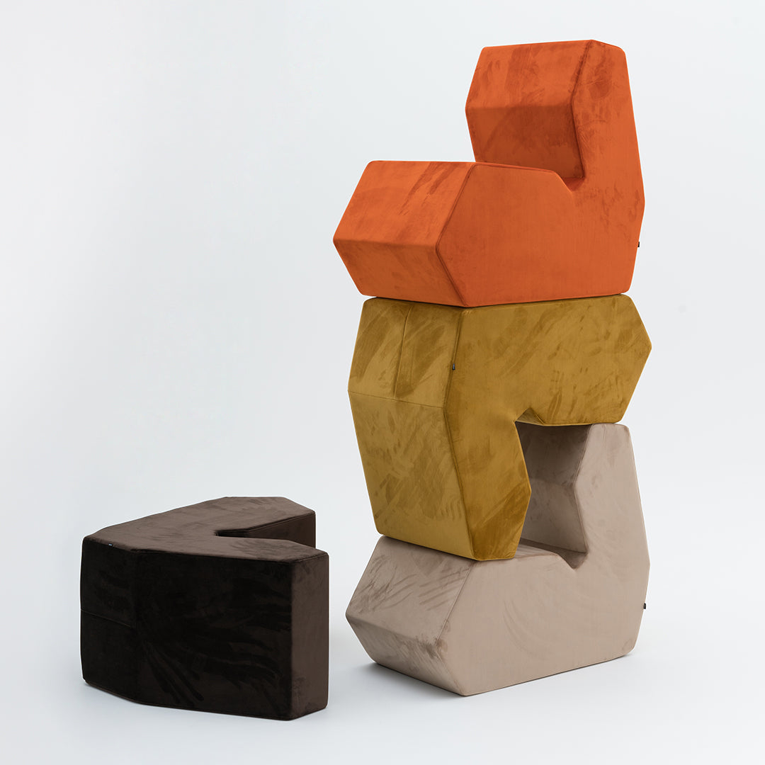 Colorful geometric stacking blocks in orange, yellow, brown, and beige with textured surfaces.
