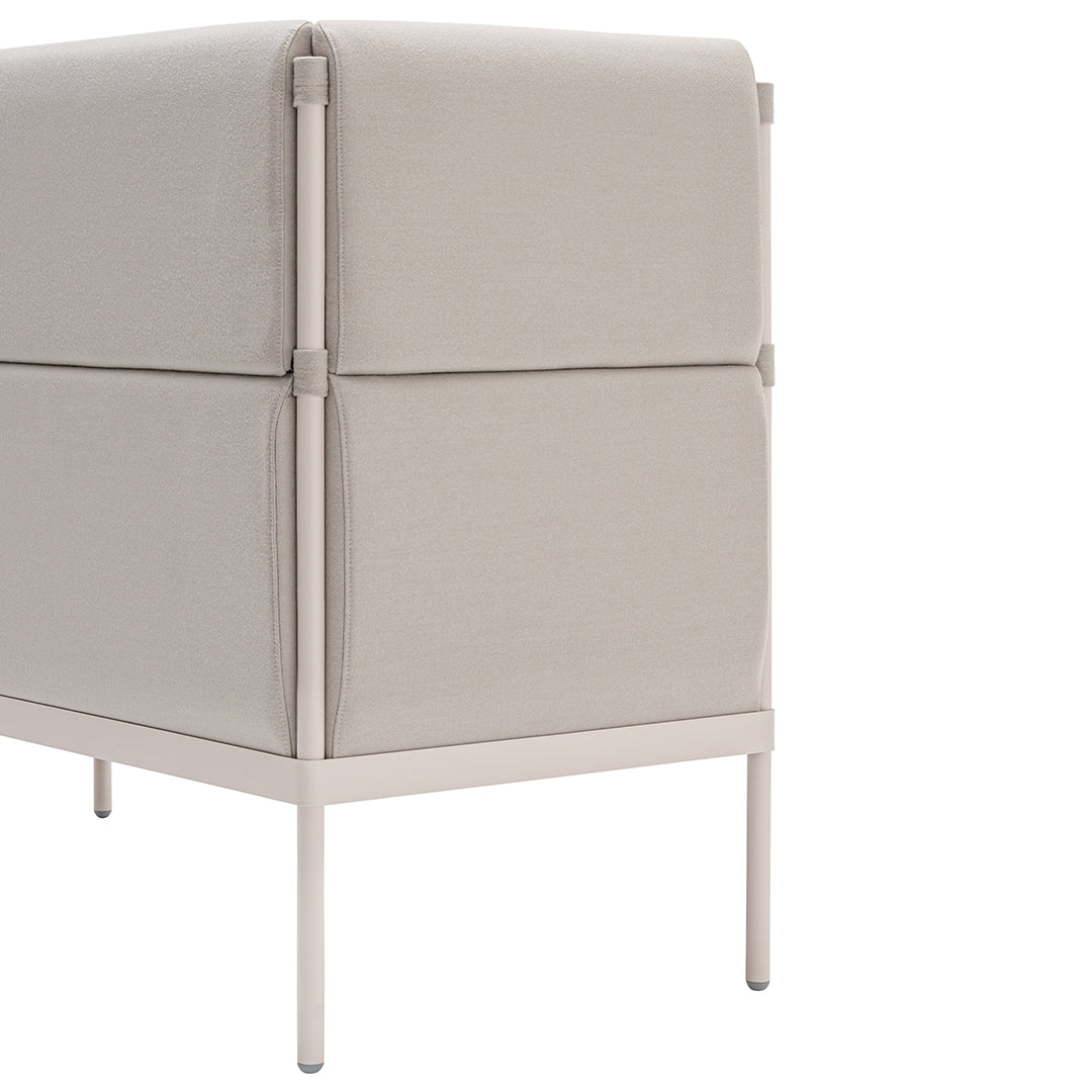 Beige fabric storage ottoman with a smooth texture and minimalist design, featuring sleek light-colored metal legs.