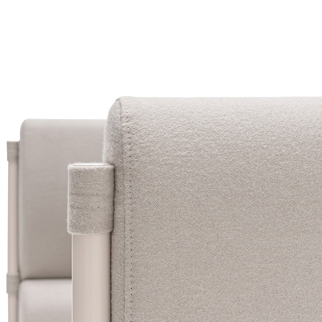 Light beige fabric upholstery with a subtle texture, complemented by sleek, minimalist metal accents.