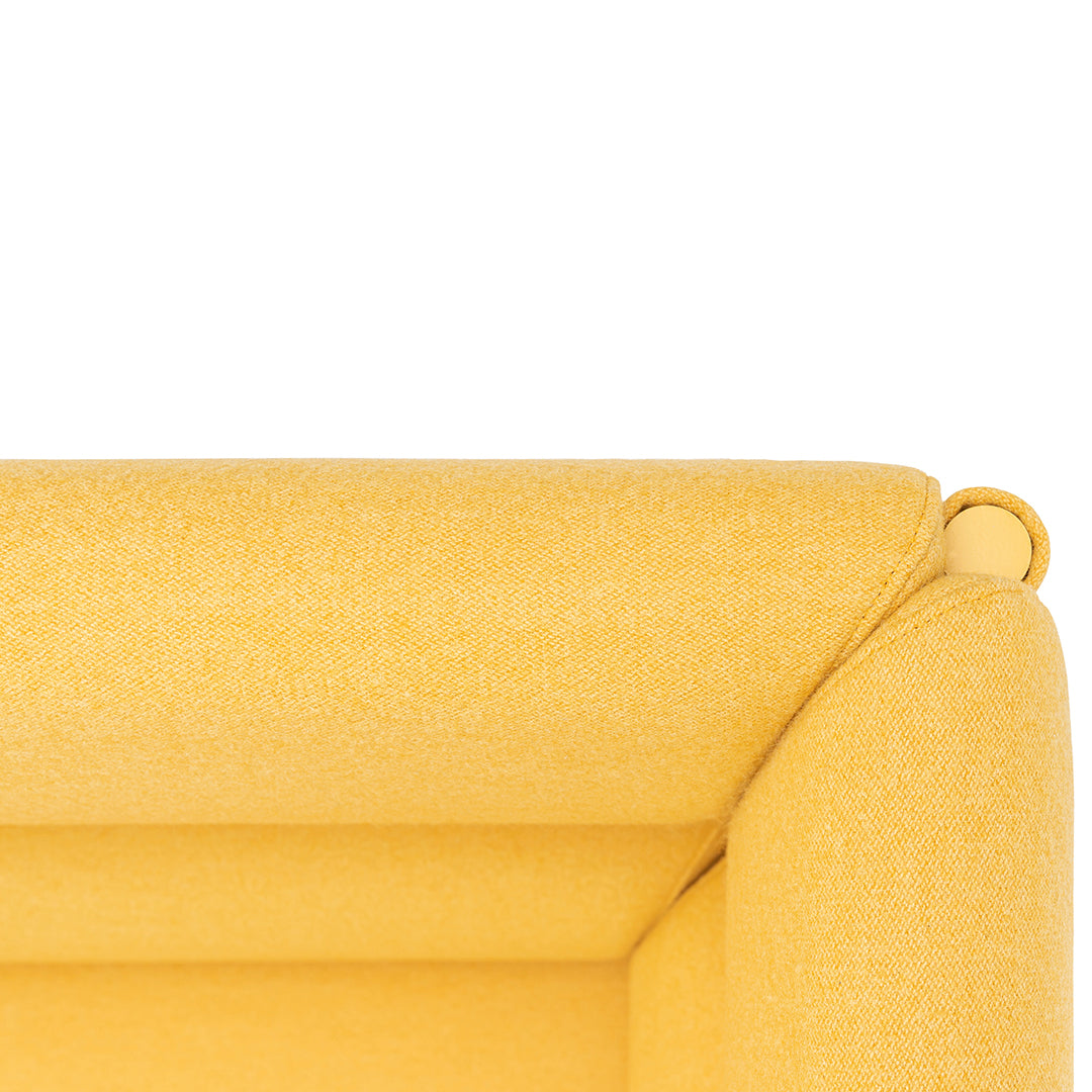 Bright yellow sofa corner with a smooth, textured finish, adding a pop of color to any space.