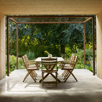 "Modern outdoor dining set featuring natural wood tones and sleek geometric lines against a lush green backdrop."