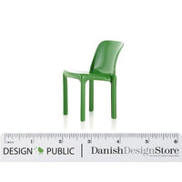 Green plastic chair with a sleek, modern design. Simple shape and vibrant color. Ideal for contemporary spaces.