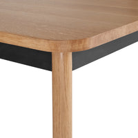Wooden table with a natural oak finish and sleek black edges, showcasing a minimalist design and smooth textures.