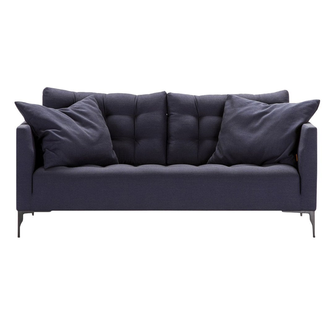 Navy blue tufted sofa with matching cushions, featuring a sleek modern design and subtle texture.