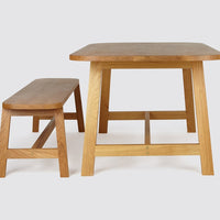 Natural oak table and bench set showcasing warm wood tones and clean, simple lines. Ideal for minimalist decor.