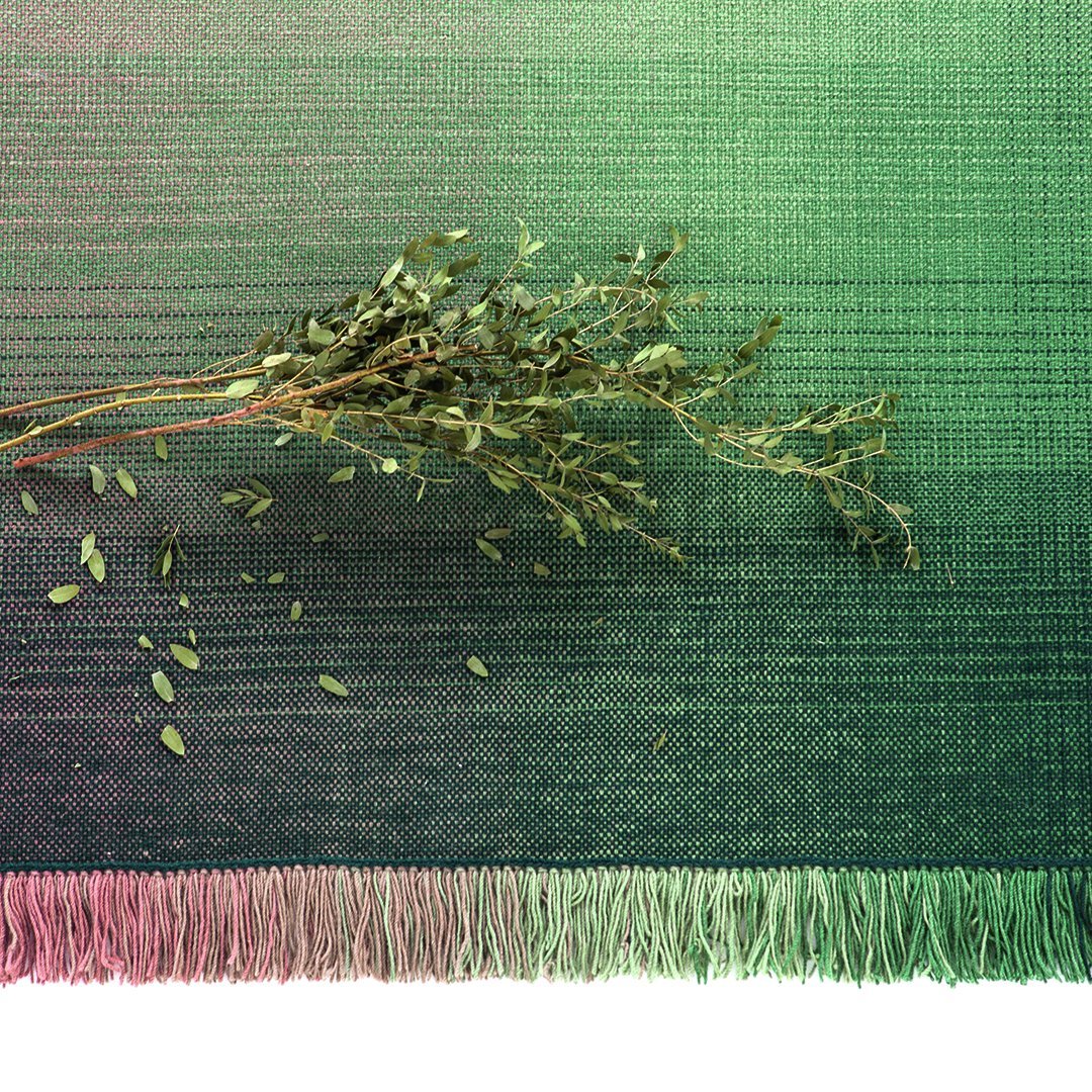 Gradient green textile with subtle texture, featuring a fringe edge, and scattered leaves for a natural touch.
