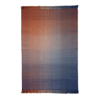 "Gradient woven blanket with warm orange to cool blue ombre, featuring soft fringed edges."