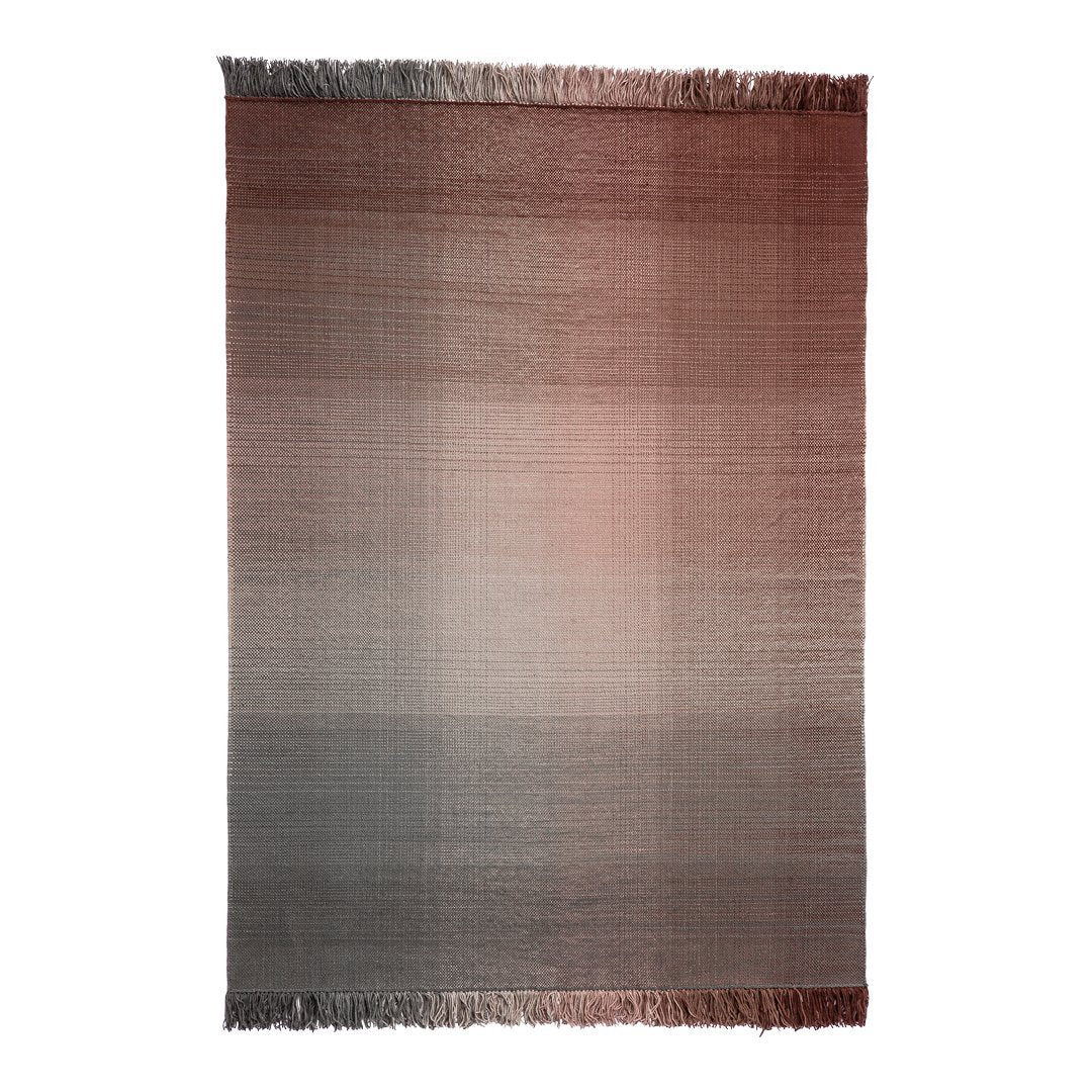 Ombre pattern rug featuring warm shades of red fading to soft gray, with fringed edges for added texture.