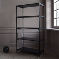 Four-shelf black metal storage unit against a light gray wall, featuring a minimalist design with clean lines.