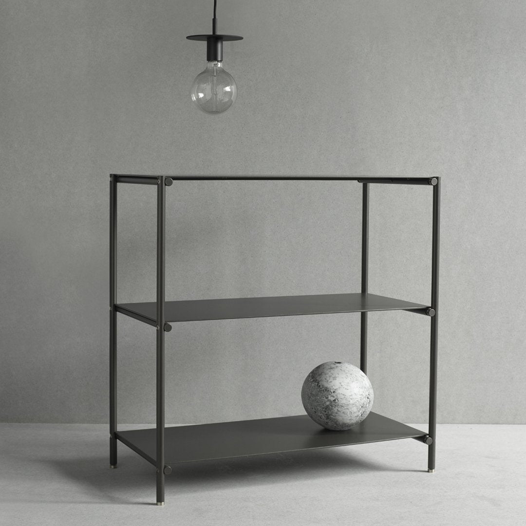 Sleek black metal shelving unit with two shelves, minimalist design against a soft gray background.