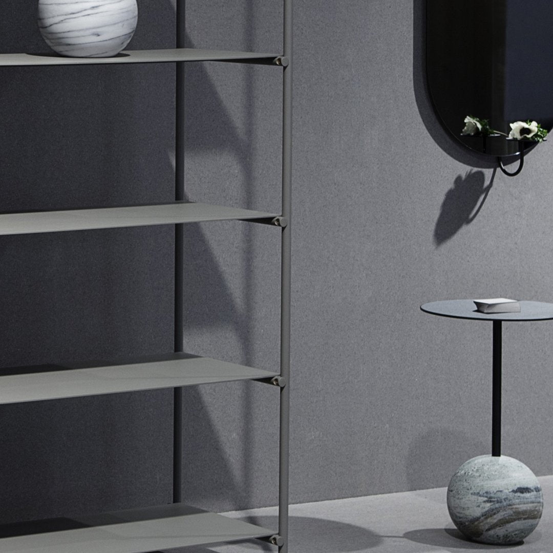 Modern gray shelving unit with sleek metal accents and subtle stoneware decor, showcasing minimalist design.