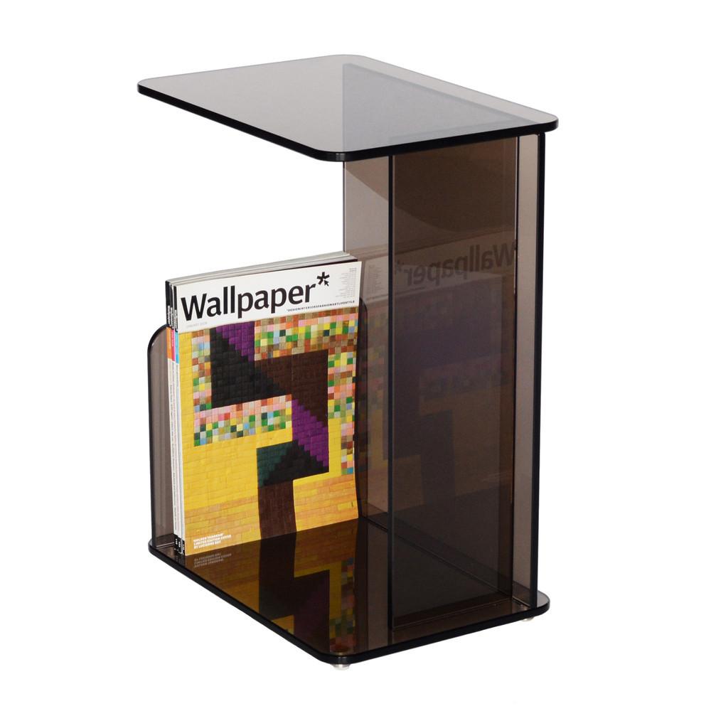 Smoky brown transparent side table with clean lines and minimalist design, featuring a vibrant patterned magazine.
