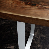 Natural wood grain in rich brown tones with sleek silver metal legs, featuring a modern design and unique patterns.
