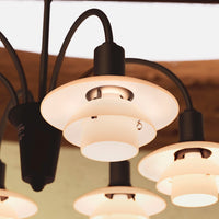 Black and frosted glass pendant lights with a sleek, modern design featuring circular shades and smooth lines.