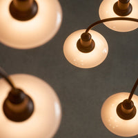 "Close-up of modern pendant lights with frosted glass shades and dark metal accents, creating a stylish illumination."