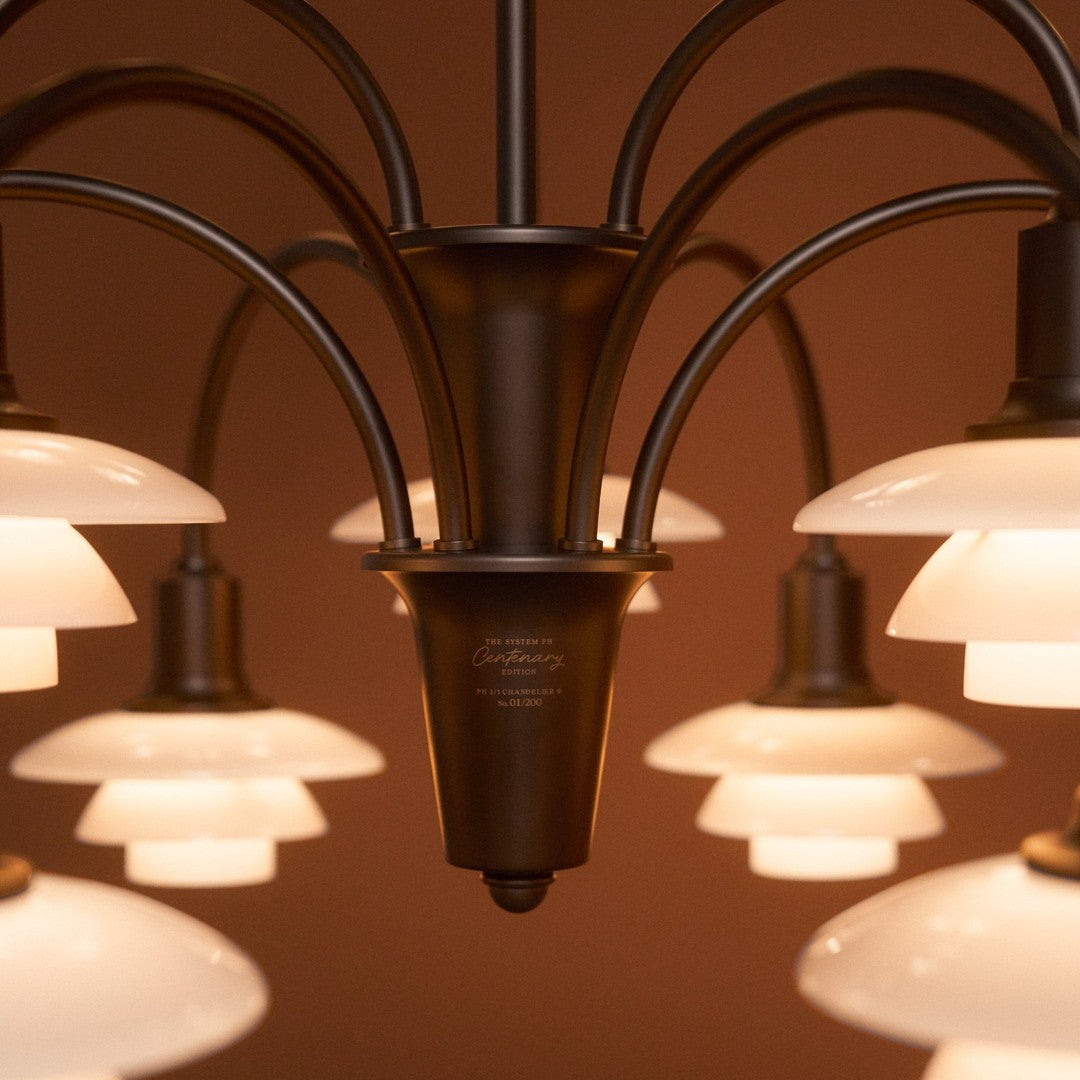 "Bronze chandelier with white glass shades creating a sleek and modern design."