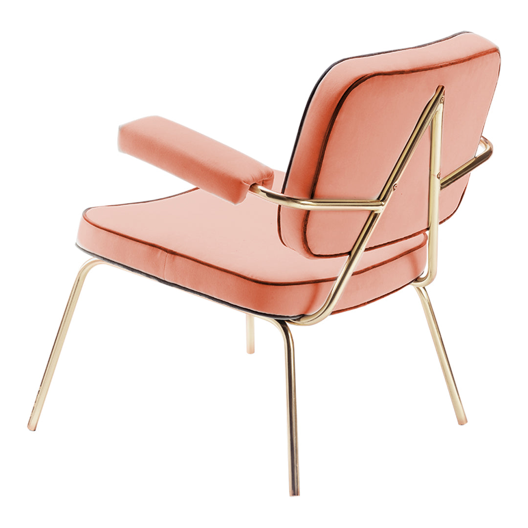 Coral pink upholstered chair with gold accents and black piping, featuring a sleek modern design.