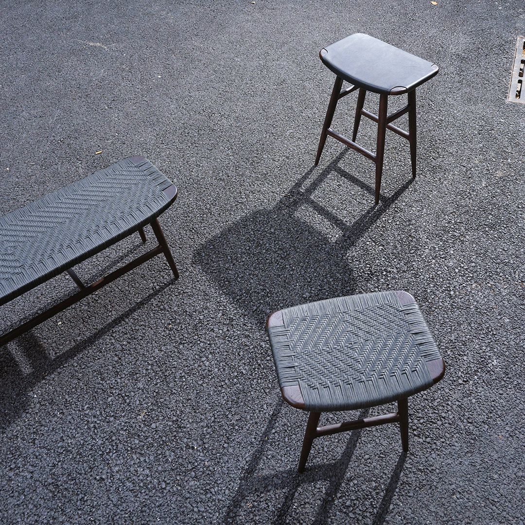 Set of three grey stools with textured patterns, featuring a sleek, modern design on a dark surface.