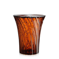 Amber glass stool with textured, vertical stripes and a flared design. Perfect for modern decor.