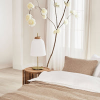 Neutral beige bedding with textured patterns, paired with soft white accents and earthy wood tones.
