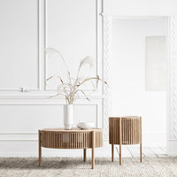 Natural wood coffee table and side table with vertical slats, set against a minimalist white backdrop.
