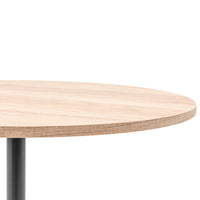 Round wooden table top with a light natural wood finish and sleek black metal base, showcasing a modern design.