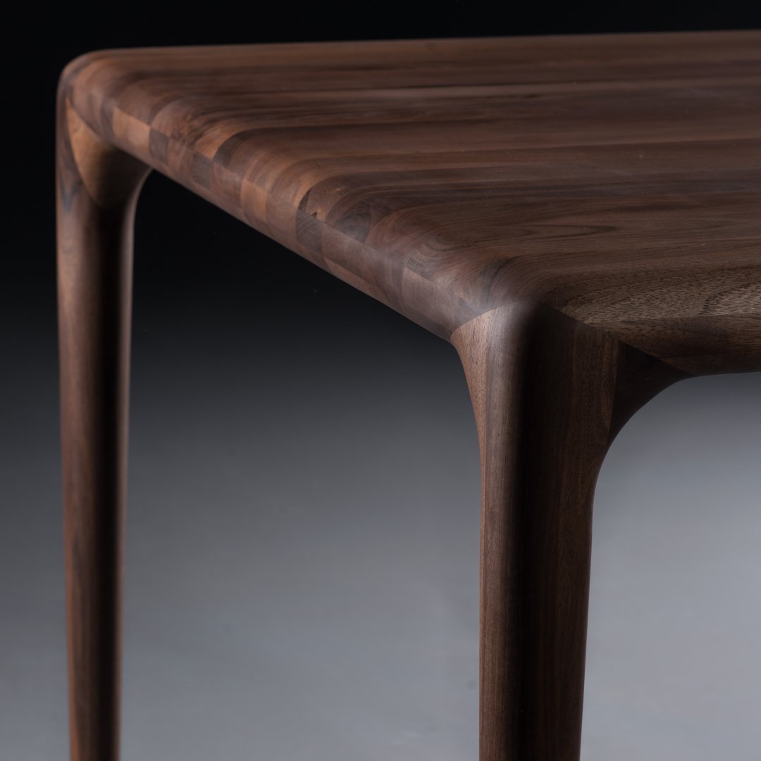 Dark walnut wood table with smooth, polished surface and subtle wood grain patterns. Elegant, modern design.