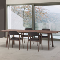 Modern wooden dining table with a rich brown finish and minimalist black chairs, complementing neutral-toned decor.
