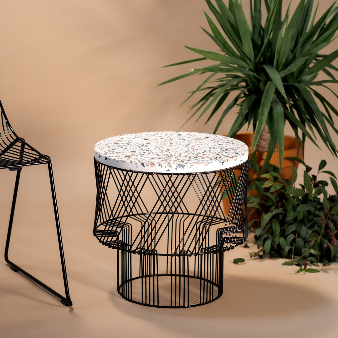 Round coffee table with a patterned white top and sleek black wire frame; perfect for modern interiors.