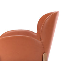 "Close-up of a sleek, orange-brown leather chair with smooth curves and a minimalist design."