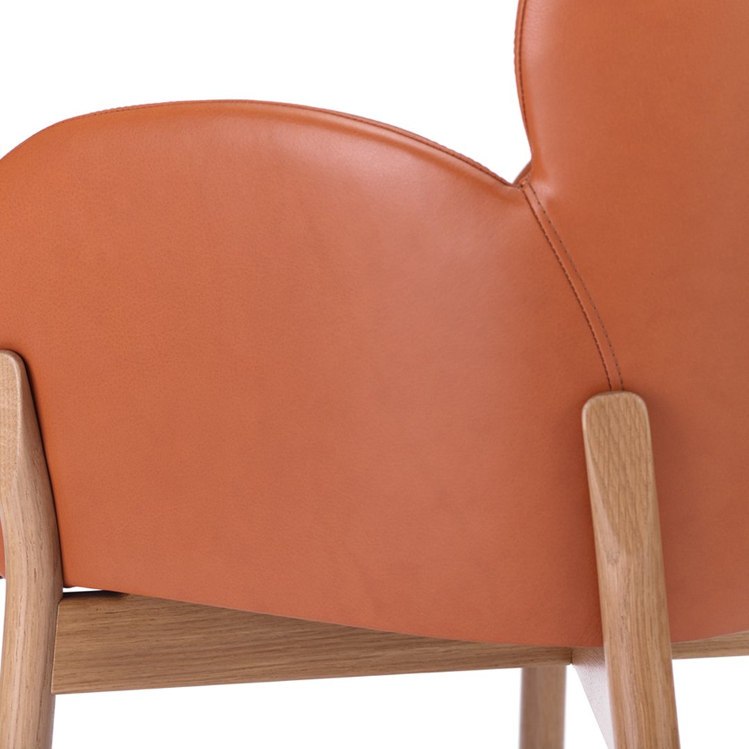 Smooth orange leather upholstery with a curved design, complemented by natural wood legs. Ideal for modern decor.