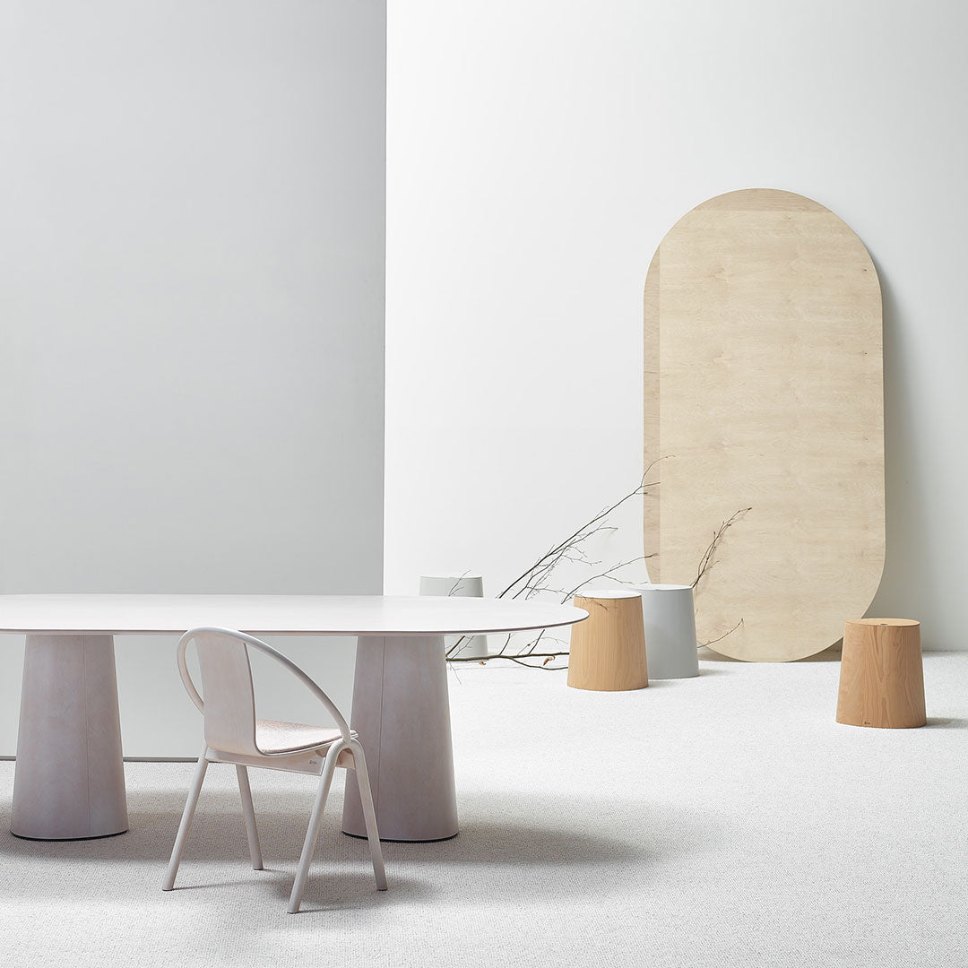 Minimalist interior featuring soft gray walls, pale wood accents, and muted white and beige furniture with textures.