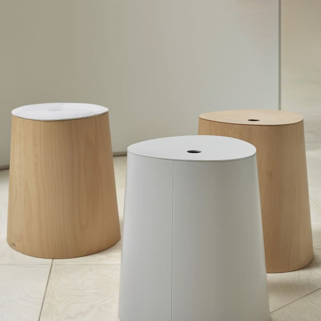 Three modern stools: light wood, matte white, and natural wood finish, featuring simple geometric shapes.