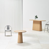 Wooden tables with natural oak finish, minimalist design, set against a light, neutral backdrop.