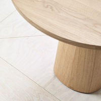 Light wood table with subtle grain patterns on a pale wood floor, creating a warm, natural aesthetic.
