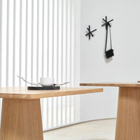 Light wood table with a smooth finish, contrasting black serving tray, and white ceramic cup in a minimalist setting.
