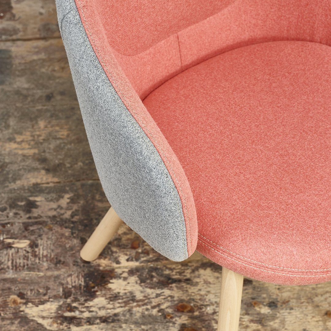 Pink and gray upholstered chair with a textured finish and light wooden legs, perfect for modern interiors.