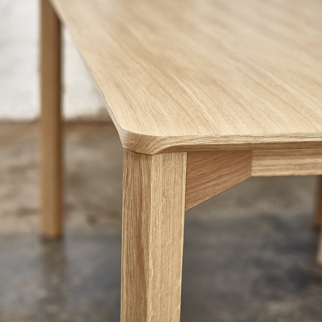 Light oak wood table with a smooth surface and rounded edges, highlighting natural grain patterns.