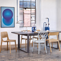 Modern dining room with a gray table, wooden chairs, and blue geometric wall art. Elegant colors and clean lines.