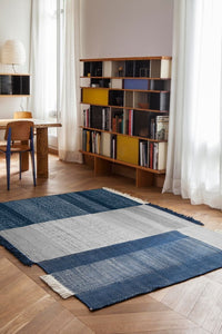 Blue and gray striped area rug with a textured pattern, featuring a modern design for stylish home decor.