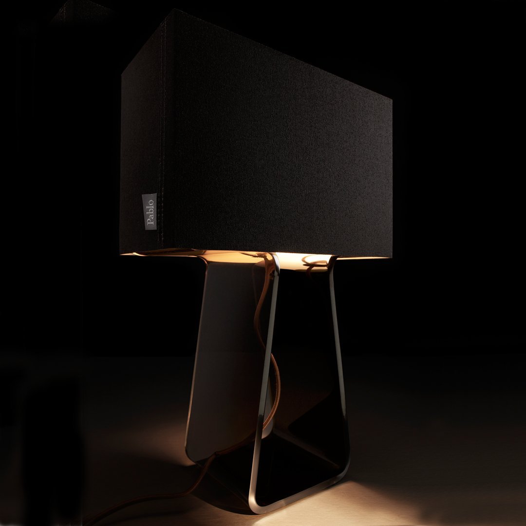 Black fabric lampshade with a sleek, modern design, featuring warm light and a contrasting metal base.