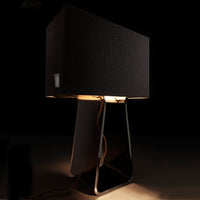 Black fabric lampshade with a sleek, modern design, featuring warm light and a contrasting metal base.