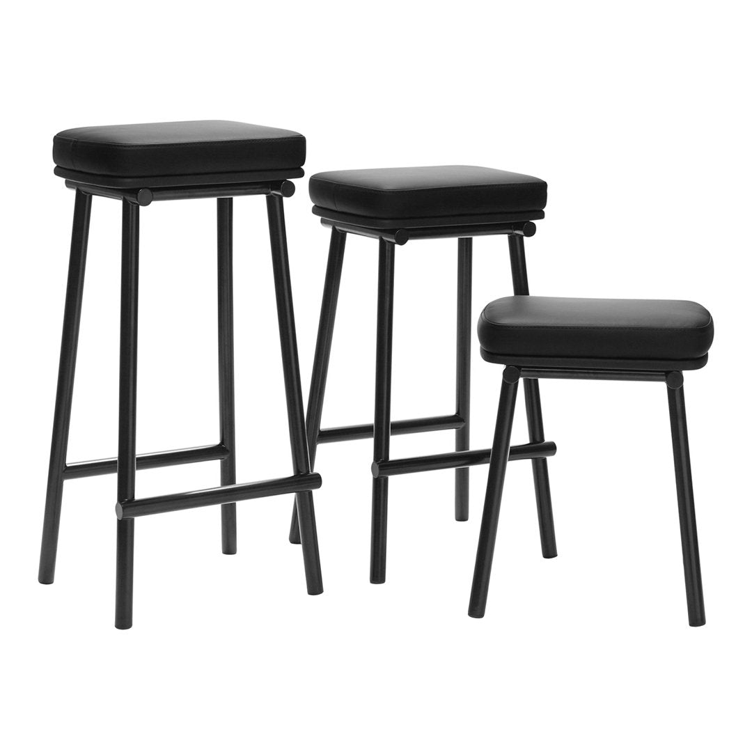 Set of three stylish black bar stools with smooth, cushioned seats and sleek metal legs, perfect for modern decor.