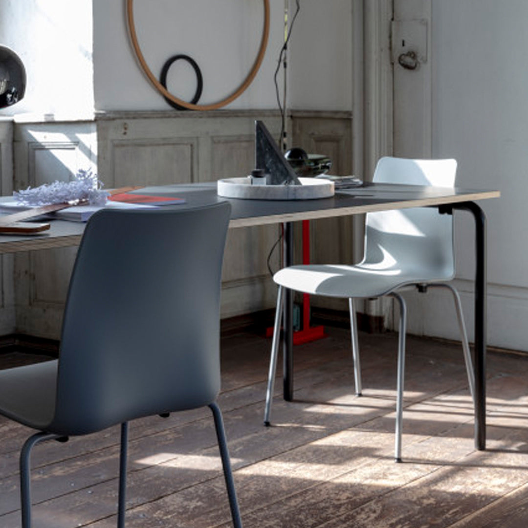 Grey and white modern chairs with sleek design, set against a wooden floor and minimalist decor.