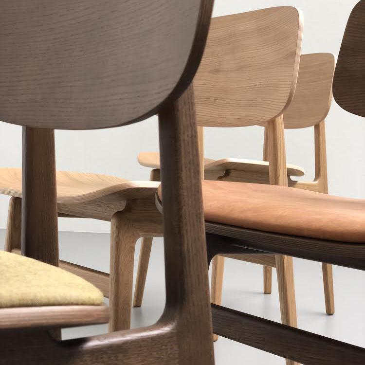 Set of modern chairs featuring light wood tones, a dark brown frame, and a pop of yellow upholstery.