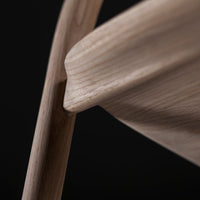 Light wood texture with smooth curves and subtle grain patterns against a dark background.