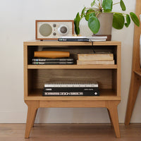 Natural wood finish nightstand with minimalist design, featuring smooth lines and a subtle textured pattern.