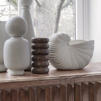 Elegant white vases and a textured dark wood vase showcasing minimalist design and neutral tones.