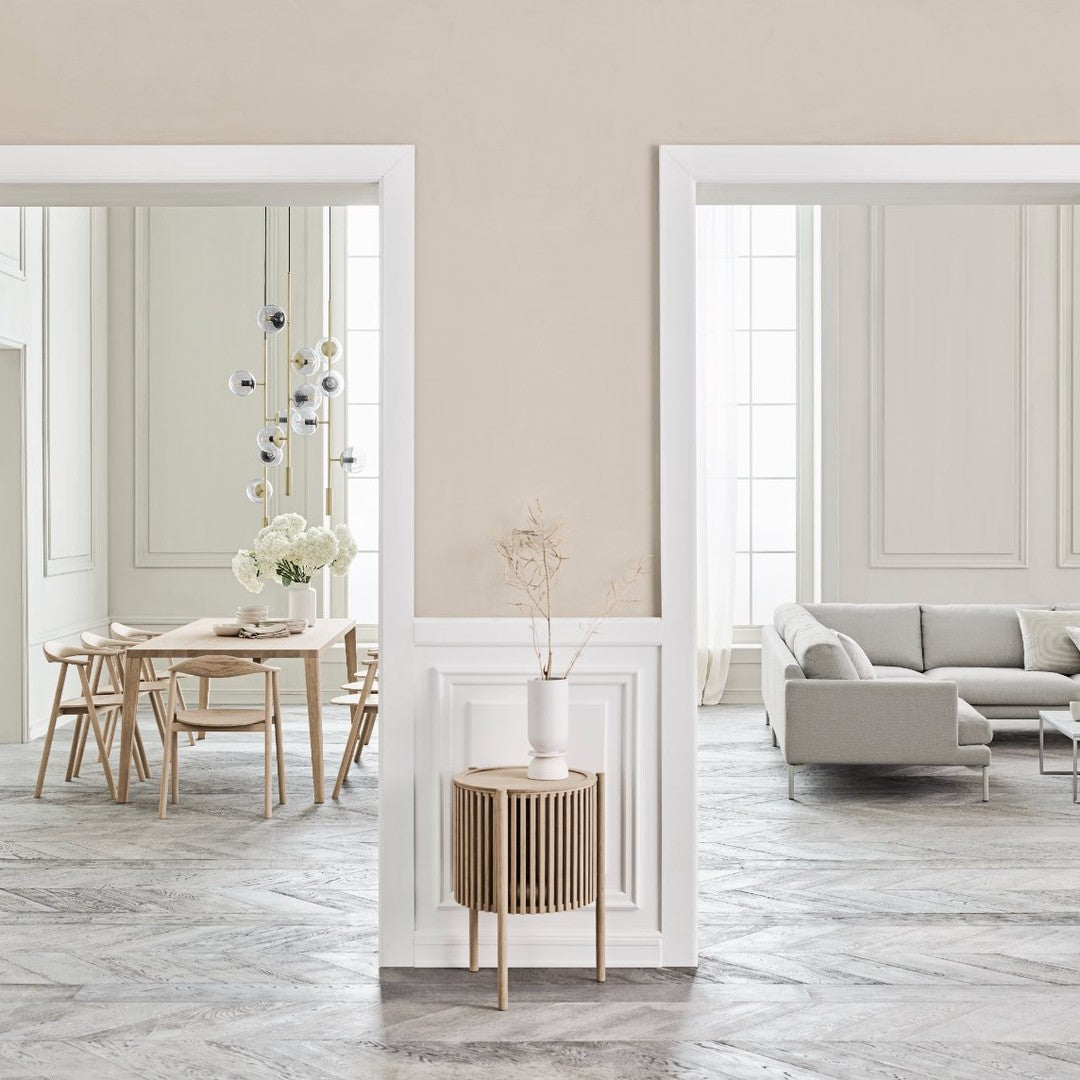 Muted beige walls and light wood accents; sleek gray flooring and soft white furnishings create a modern, airy feel.