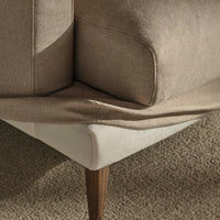 Tan and beige fabric corner of a sofa with wood legs, showcasing clean lines and a smooth finish.